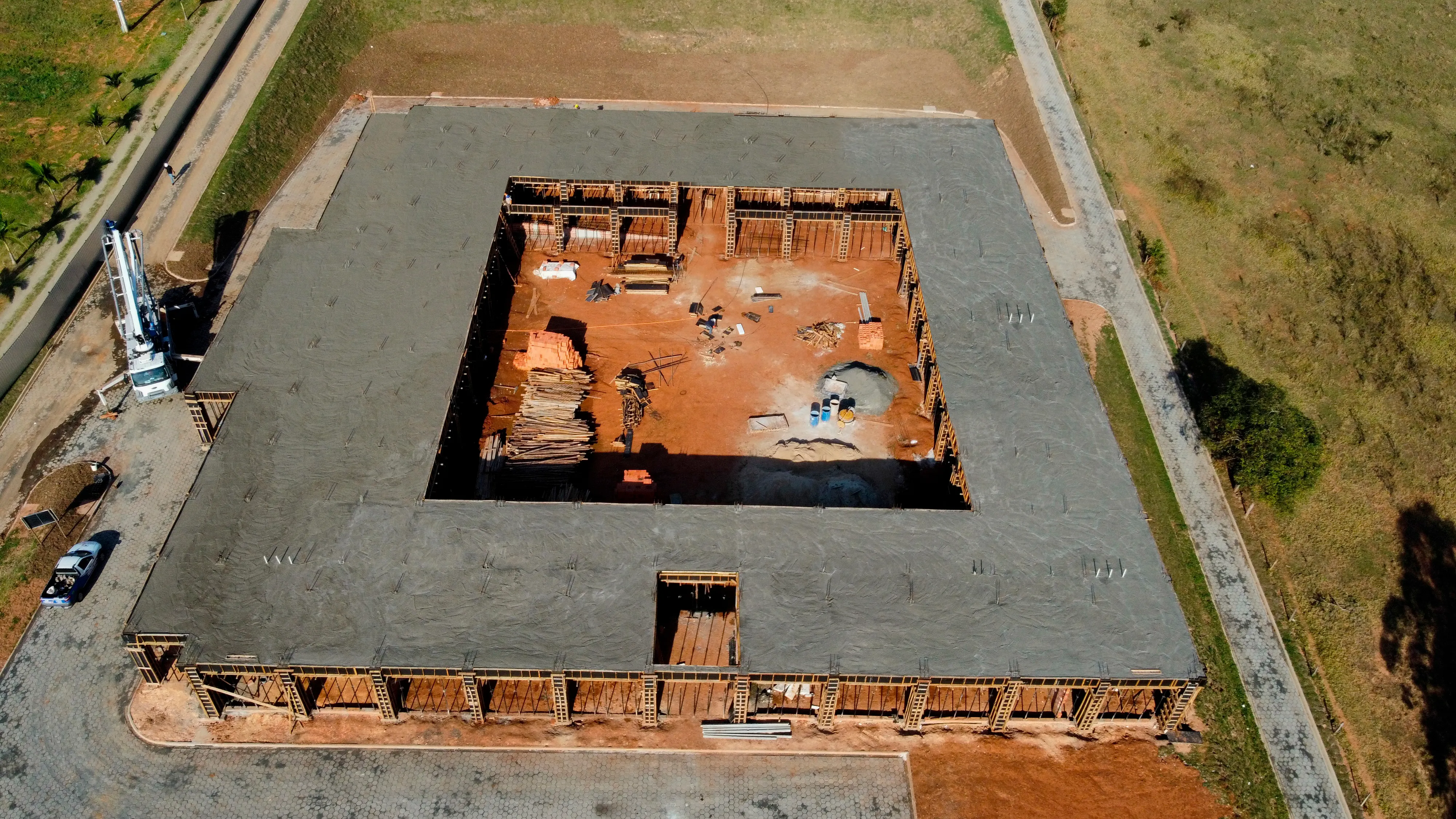 Vista aérea de uma fundação de concreto recém-concretada, com a área central ainda em escavação