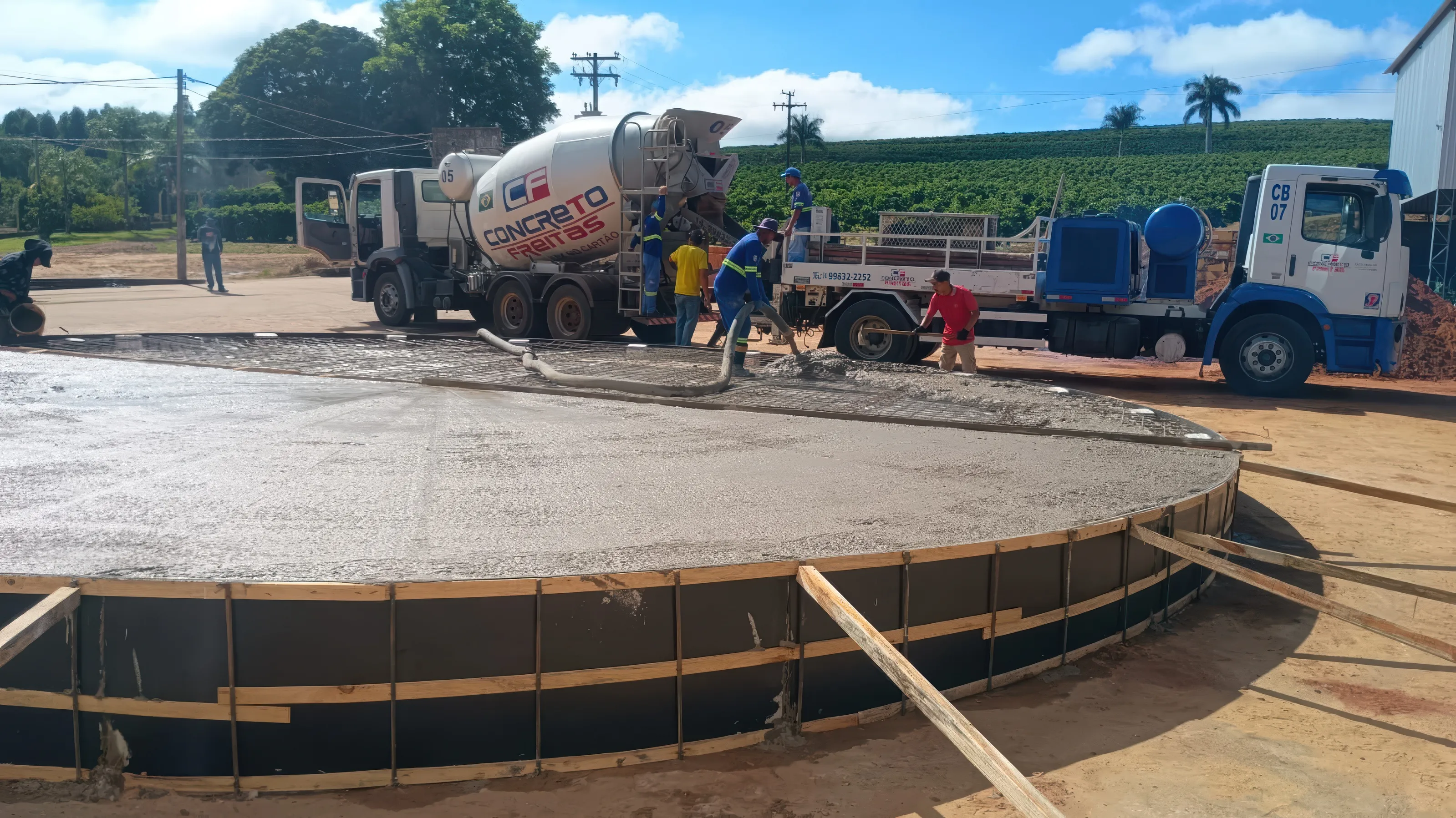 Concretagem de uma laje circular com equipe e caminhão betoneira ao fundo